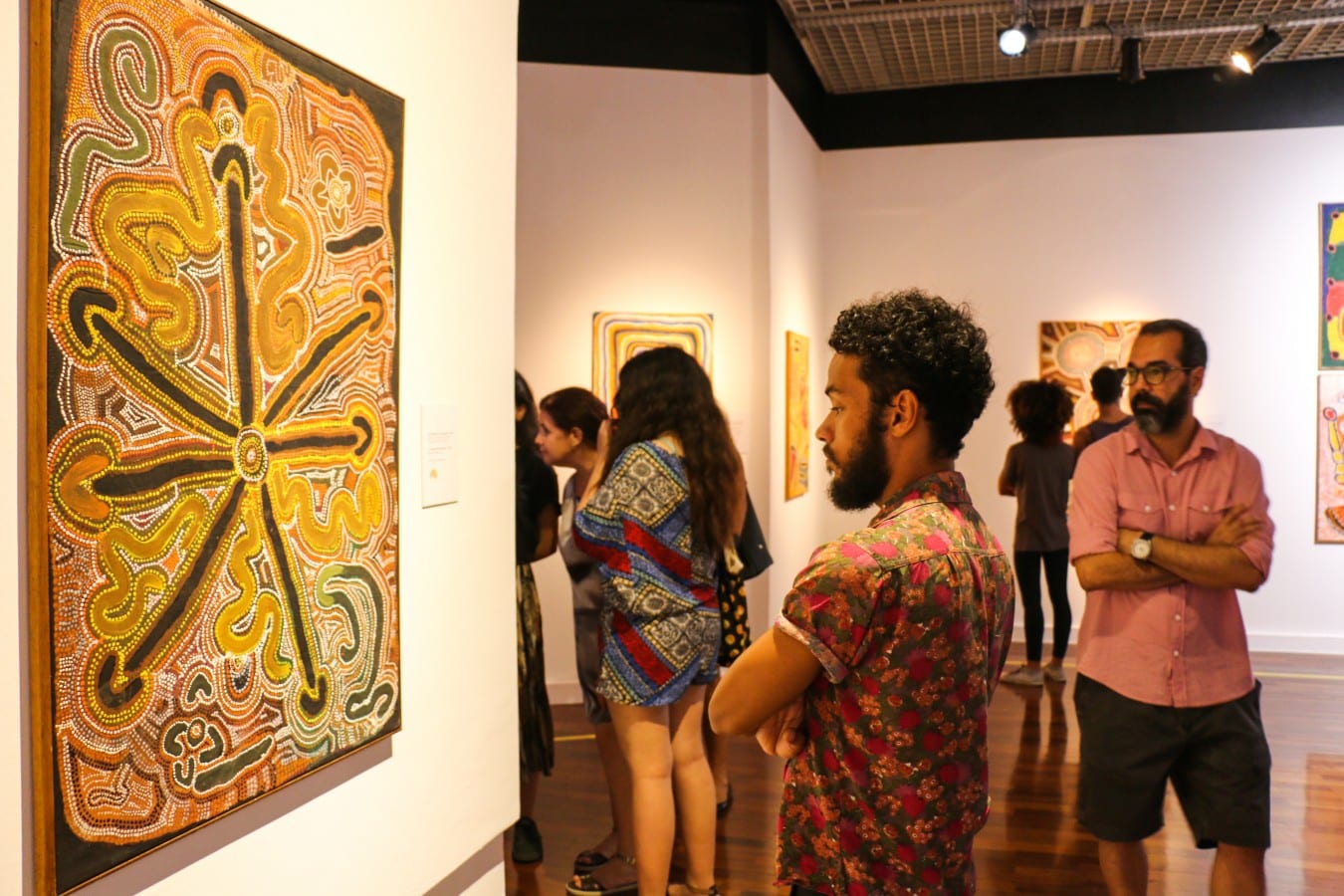Observador aprecia a obra de uma artista aborígene. Fotografia  Emmanuelle Bernard.  - O Tempo dos Sonhos: Arte Aborígene na Caixa Cultural